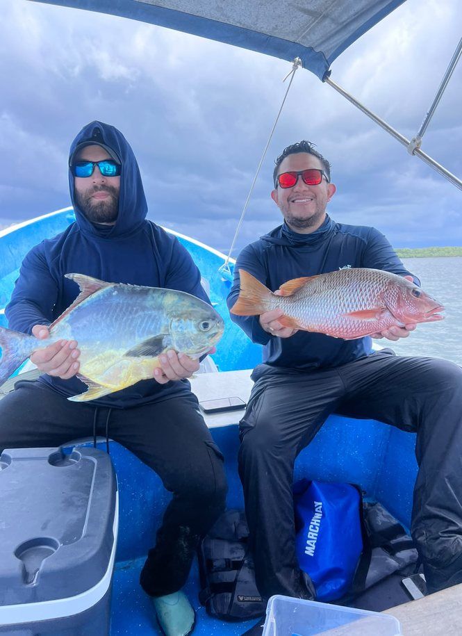 Guests holding fish on a boat in Jiquilisco Bay